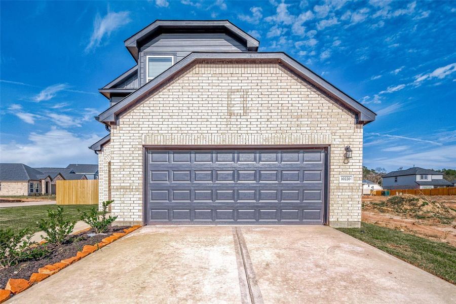 Front exterior of a new home in Mill Creek Trails, Magnolia, TX, highlighting curb appeal (Image 1).