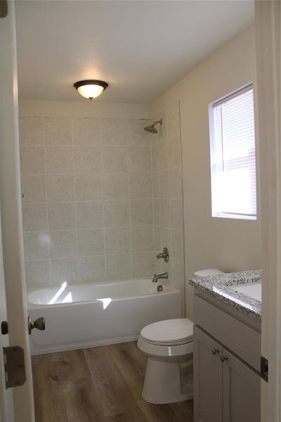 Bathroom featuring light wood-style floors, vanity, and shower / bath combination
