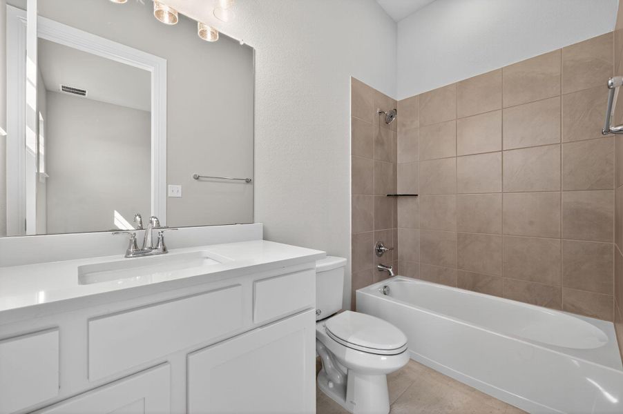 Bathroom with shower / bathtub combination, vanity, and light tile patterned flooring