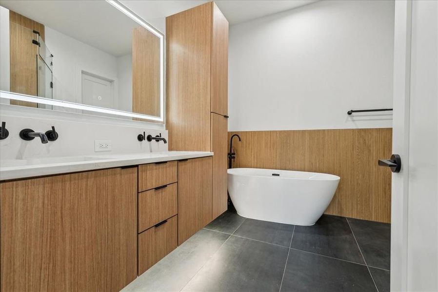 Bathroom with tile patterned flooring, a bath, and vanity