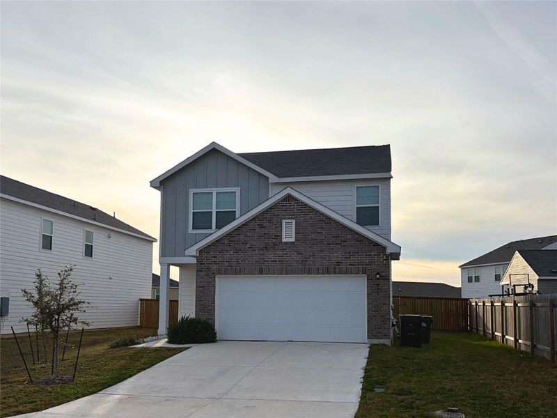 View of front of house featuring board and batten siding, a garage, concrete driveway, and brick siding View of front of house featuring board and batten siding, a garage, concrete driveway, and brick siding
