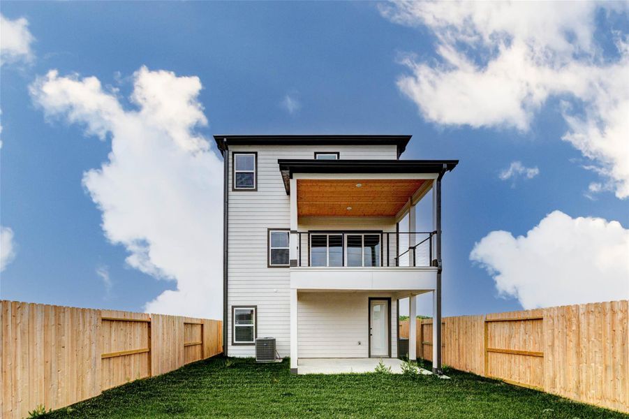 This direct rear view highlights the home’s functional outdoor layout, featuring a covered patio below and a spacious balcony above for added living space. The fenced yard provides a secure and private environment, while the simple, clean design ensures low maintenance and maximum usability. It’s a perfect extension of the home’s interior living areas. The picture shown is from the model home with the same floor plan, Rev floor plan.