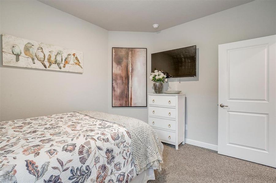 Bedroom featuring light carpet and baseboards