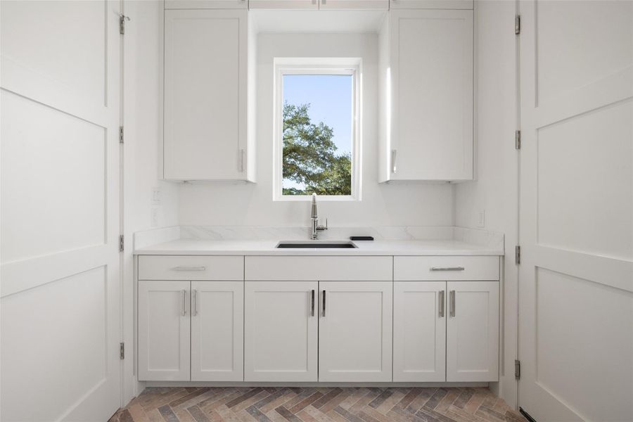 Laundry Room with Sink, Storage and Access to the Garage.