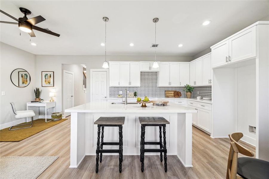 Sleek and modern, the kitchen features a large island, elegant backsplash, and recessed lighting for a fresh, contemporary feel.