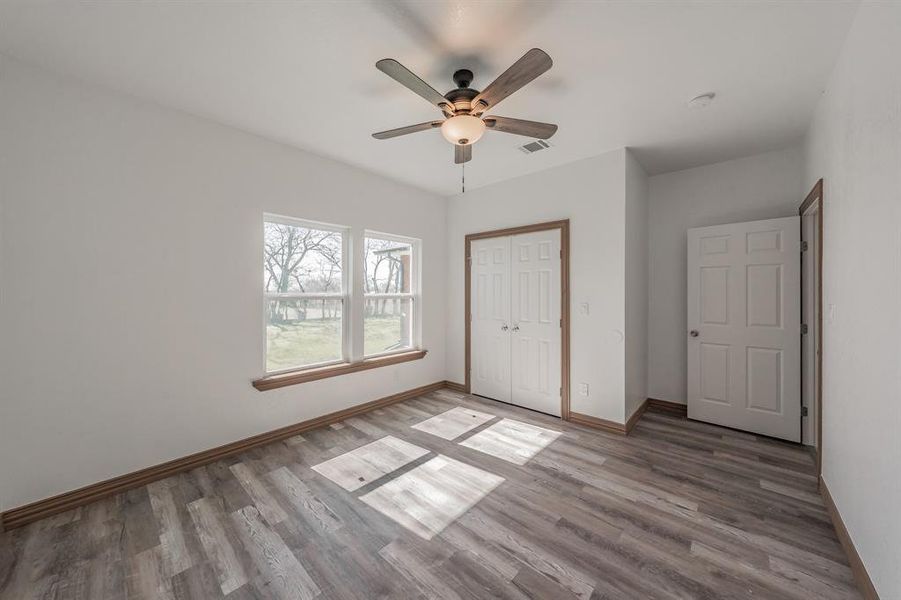 Unfurnished bedroom with light wood-type flooring, baseboards, visible vents, and a closet