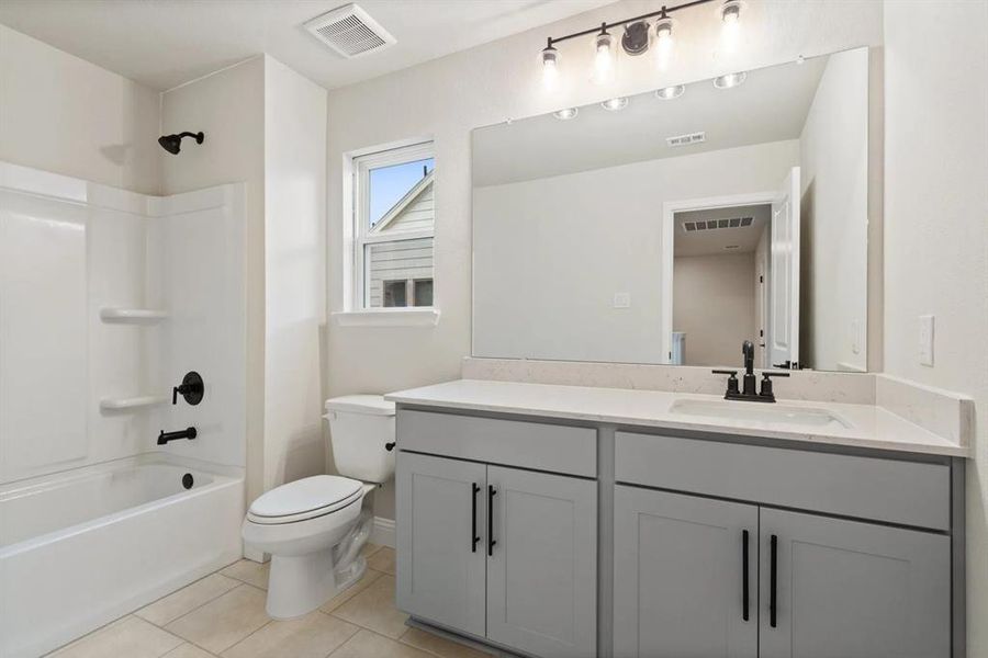 Full bathroom with tile patterned flooring, vanity, toilet, and shower / bathing tub combination