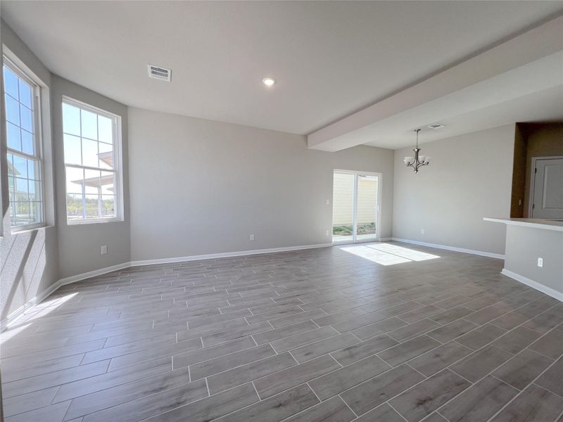 Empty room with visible vents, a chandelier, baseboards, wood finish floors, and recessed lighting Empty room with visible vents, a chandelier, baseboards, wood finish floors, and recessed lighting