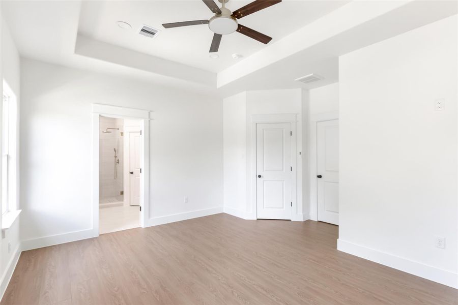Primary ensuite with trey ceiling and attached bathroom.