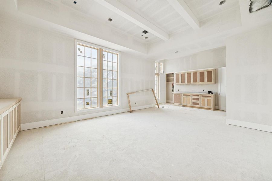 Secondary view of the expansive game room, showcasing a sleek integrated wet bar area perfect for entertaining. This versatile upstairs retreat features soaring ceilings, clean modern lines, and premium cabinetry that complements the home's contemporary aesthetic. Large windows flood the space with natural light, highlighting the spacious layout and high-end finishes of this luxury living area. Secondary view of the expansive game room, showcasing a sleek integrated wet bar area perfect for entertaining. This versatile upstairs retreat features soaring ceilings, clean modern lines, and premium cabinetry that complements the home's contemporary aesthetic. Large windows flood the space with natural light, highlighting the spacious layout and high-end finishes of this luxury living area.