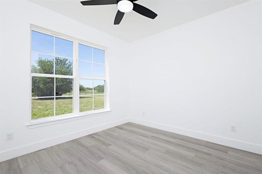 Spare room with a ceiling fan and light wood-type flooring