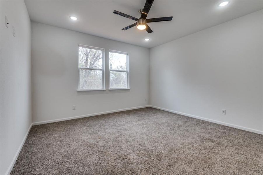 Carpeted empty room featuring ceiling fan