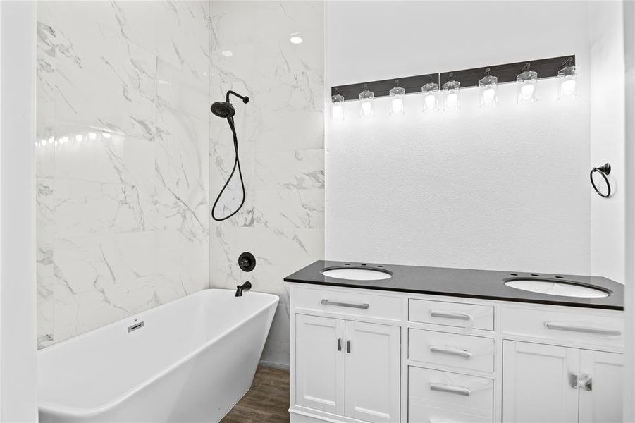 Bathroom with a bathtub, vanity, and hardwood / wood-style flooring