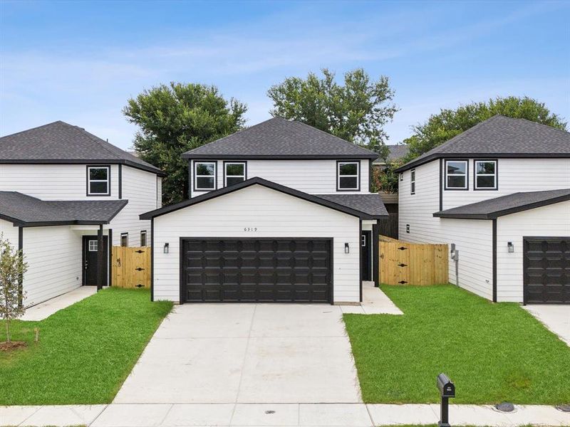 View of property featuring a garage and a front yard