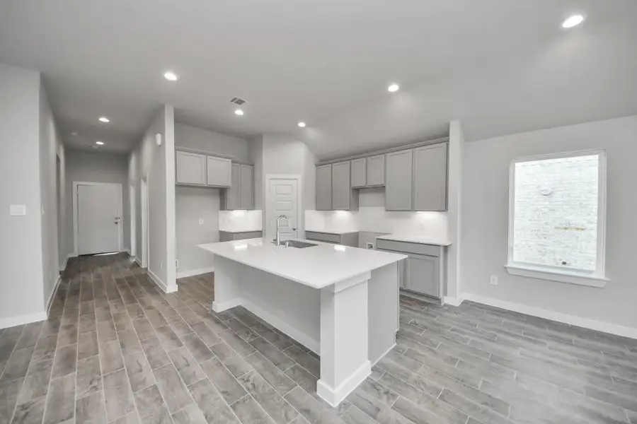 The kitchen is a culinary haven, featuring granite countertops, a tile backsplash, stainless steel appliances, 42” upper cabinets, and undercabinet lighting. Sample photo of completed home with similar floor plan. Actual colors and selections may vary. The kitchen is a culinary haven, featuring granite countertops, a tile backsplash, stainless steel appliances, 42” upper cabinets, and undercabinet lighting. Sample photo of completed home with similar floor plan. Actual colors and selections may vary.