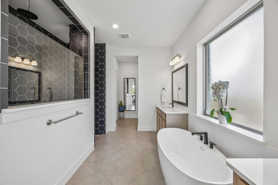 Bathroom featuring vanity, recessed lighting, walk in shower, a freestanding tub, and light tile patterned floors