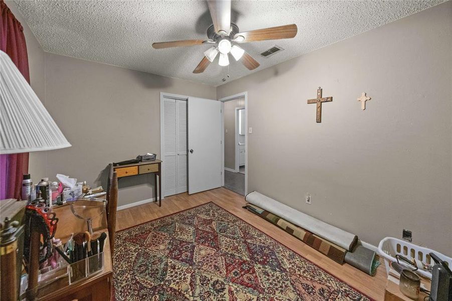 Office area featuring a ceiling fan, wood finished floors, and a textured ceiling