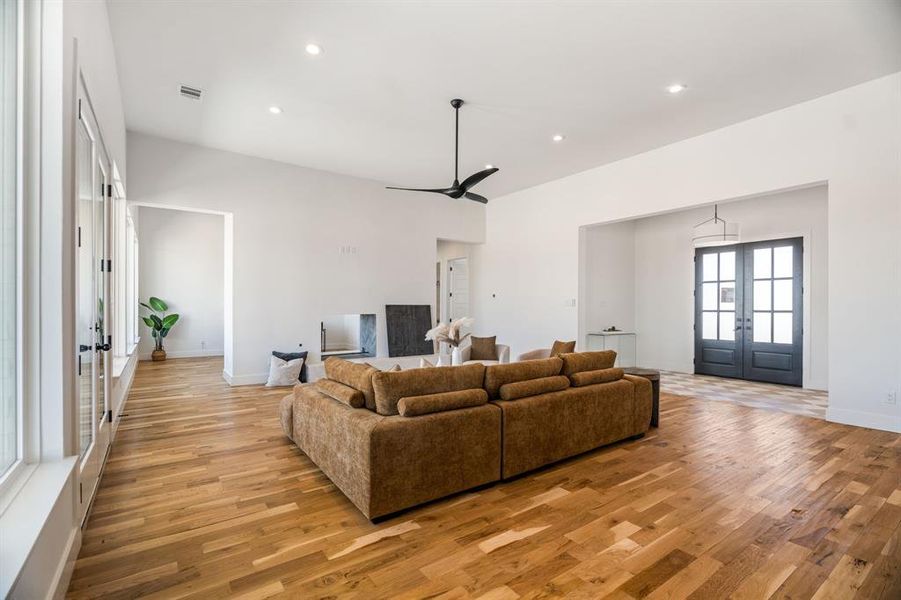 Living room with light wood-type flooring and french doors