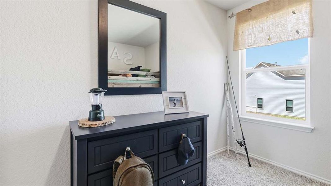 Light-colored walls and soft carpet flooring complement the natural light from the window