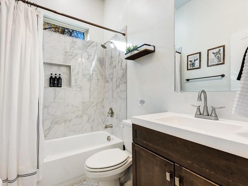 Bathroom featuring shower / bath combo with shower curtain and vanity