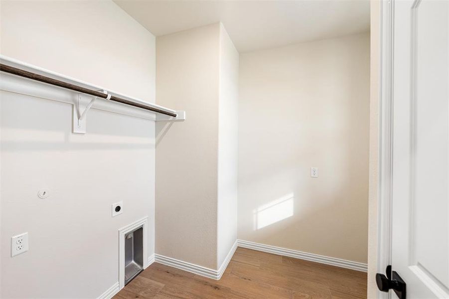 Laundry room featuring electric dryer hookup and light wood-style flooring