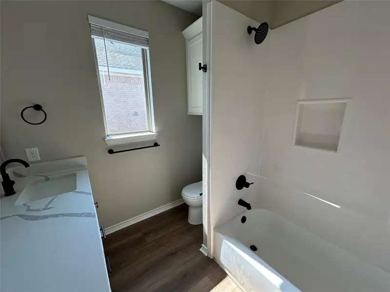 Full bathroom featuring shower / tub combination, dark wood-style floors, and vanity
