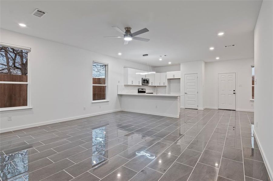 Unfurnished living room featuring ceiling fan