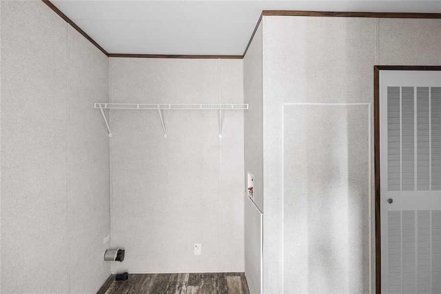 Laundry area with dark hardwood / wood-style floors