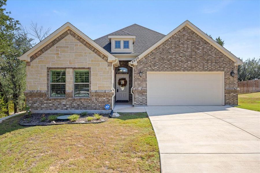 View of front of home with driveway, brick siding, and a garage View of front of home with driveway, brick siding, and a garage