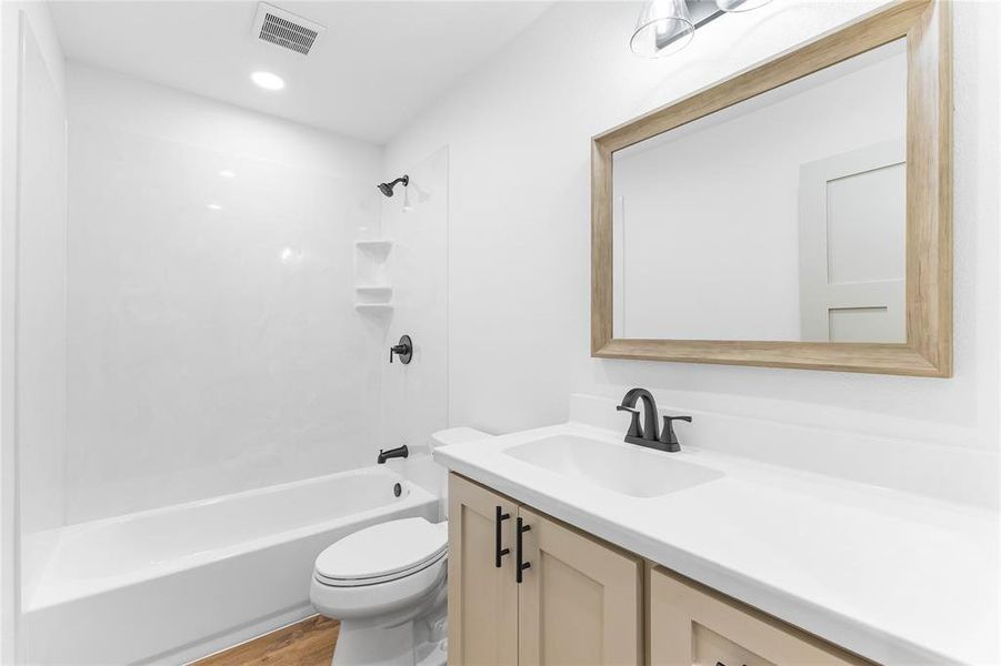 Full bathroom featuring shower combination, vanity, and light wood-style floors Full bathroom featuring shower combination, vanity, and light wood-style floors