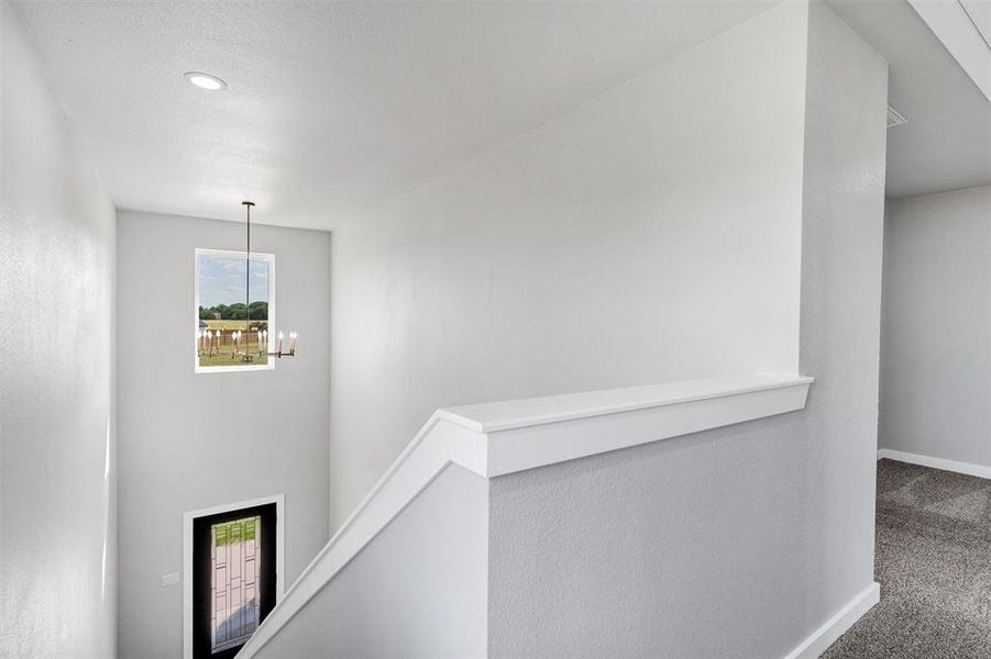 Hall featuring an upstairs landing, carpet flooring, plenty of natural light, baseboards, and recessed lighting