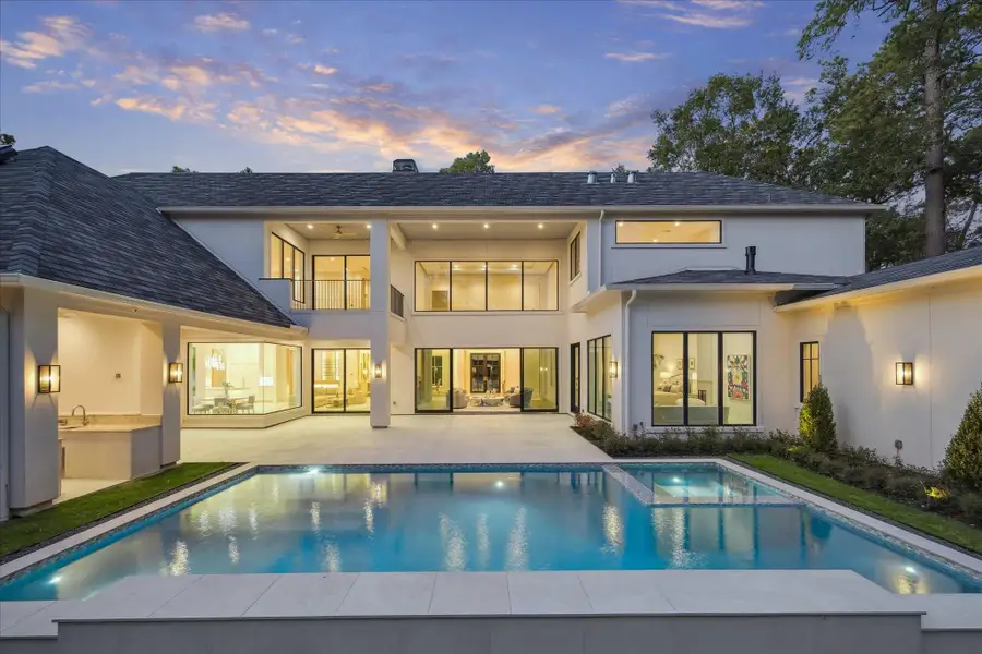 The expansive backyard features a covered patio and a fully equipped outdoor kitchen, ideal for year-round entertaining and a tranquil pool and spa.