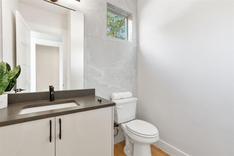 Half bathroom featuring vanity and light wood finished floors Half bathroom featuring vanity and light wood finished floors