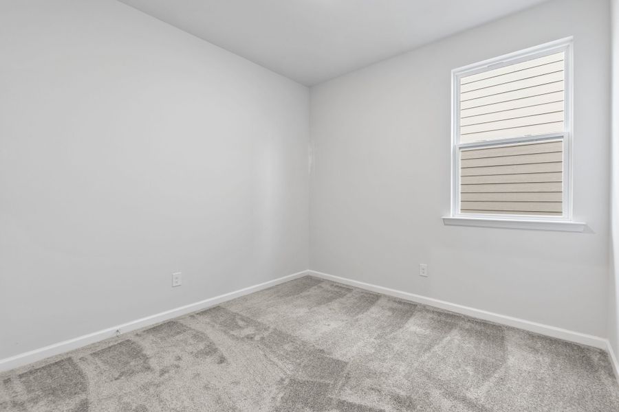 A room with a window and a rug.