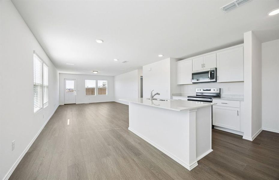 Open kitchen with adjoining nook featuring large windows and direct access to the backyard Open kitchen with adjoining nook featuring large windows and direct access to the backyard