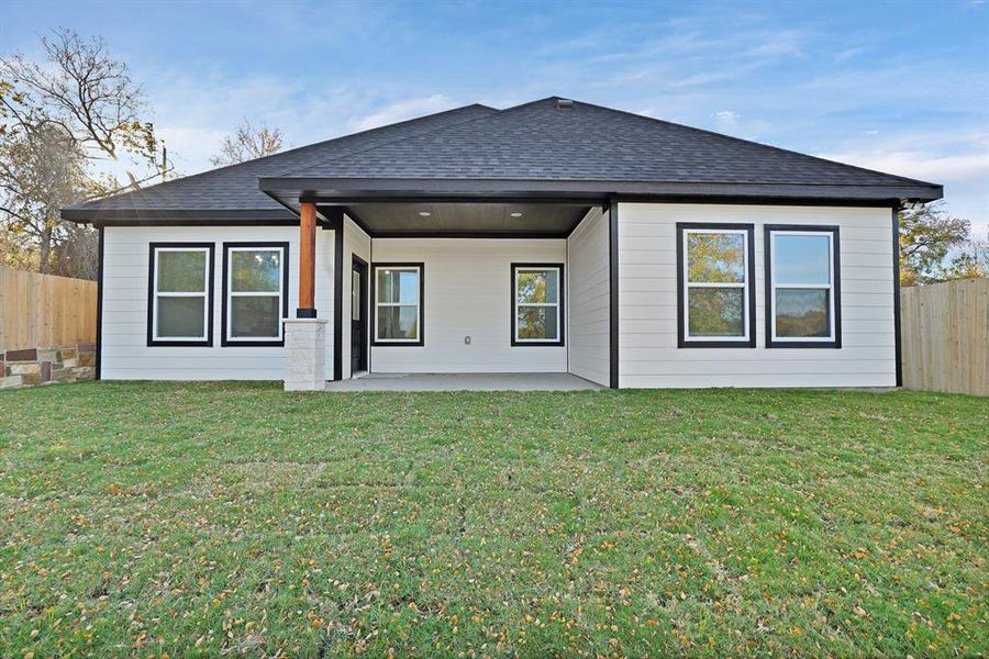 Rear view of property with a yard and a patio area