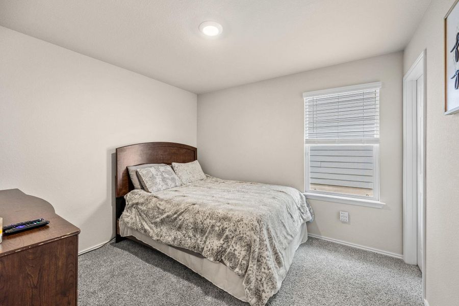 Well-lit and tranquil, this bedroom provides a perfect canvas for personalization.