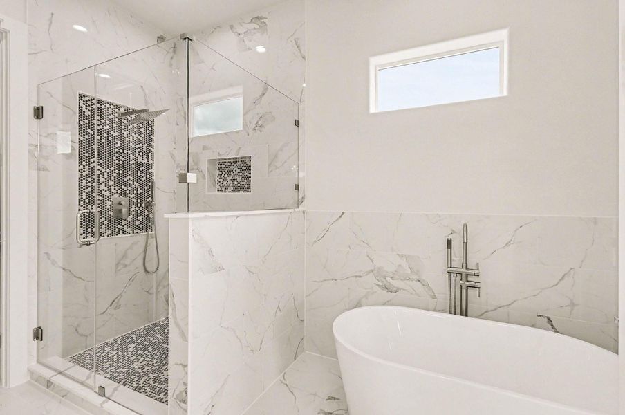Luxurious spa-style bath featuring freestanding soaking tub and oversized glass shower.