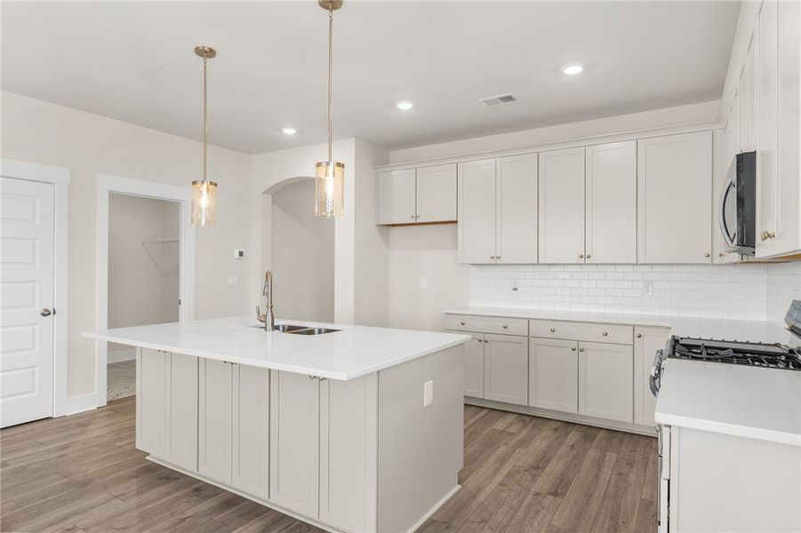This modern kitchen features a spacious island, sl