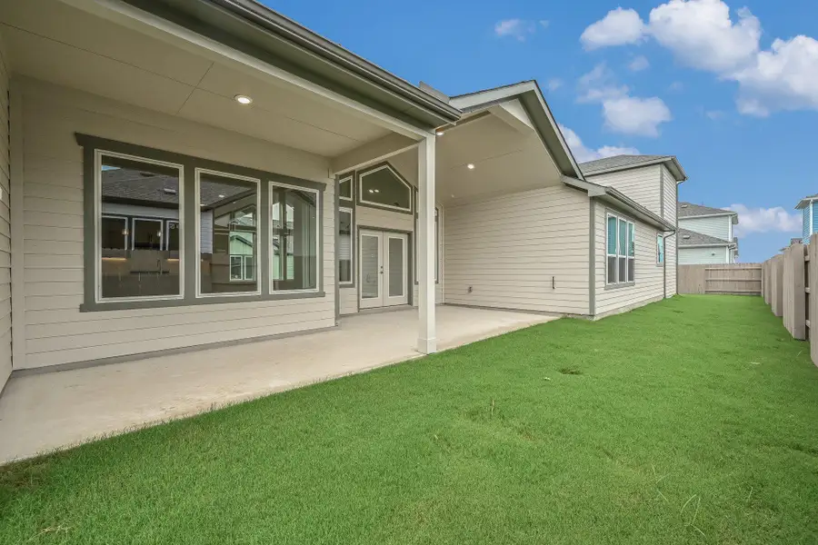 Rear view of property with a fenced backyard, french doors, and a patio area