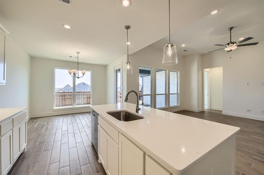 Kitchen with open floor plan, dishwasher, recessed lighting, dark wood-style floors, and a sink