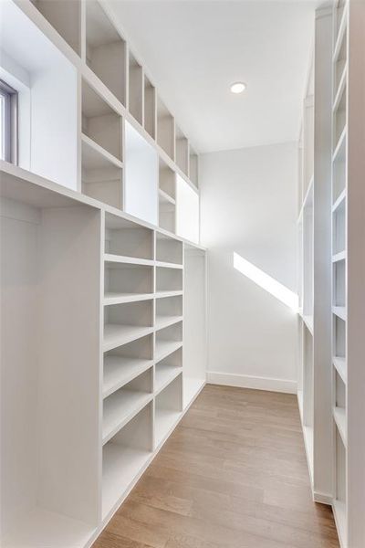 Spacious closet with light wood-type flooring Spacious closet with light wood-type flooring
