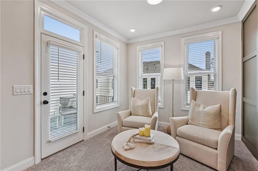 Living area featuring carpet flooring and crown molding
