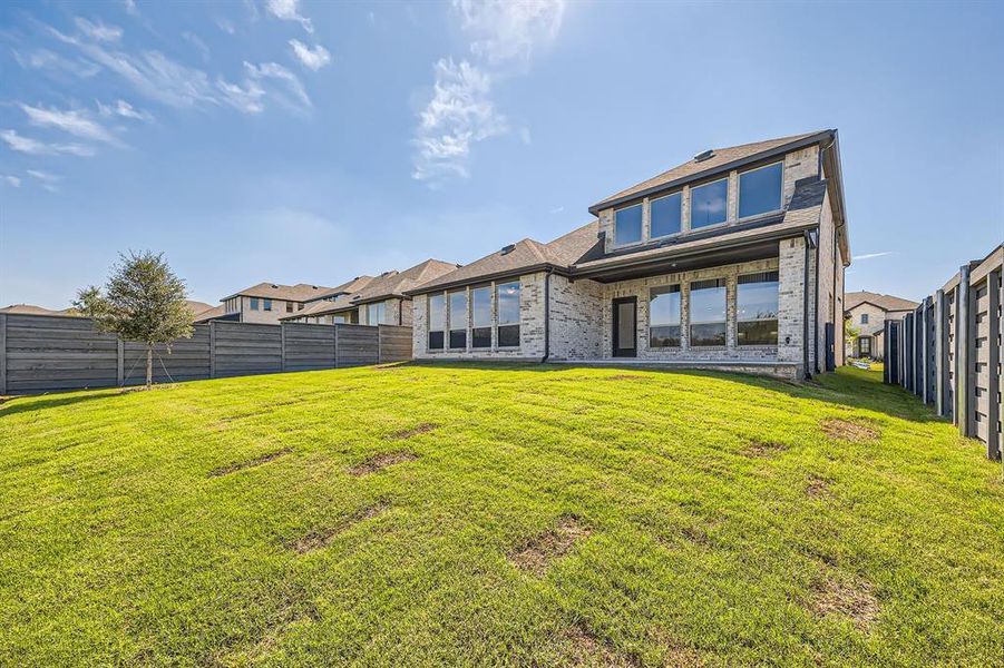 Rear view of house featuring a yard