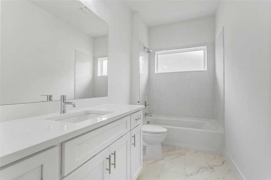 Full bathroom featuring tile patterned floors, tiled shower / bath combo, vanity, and toilet