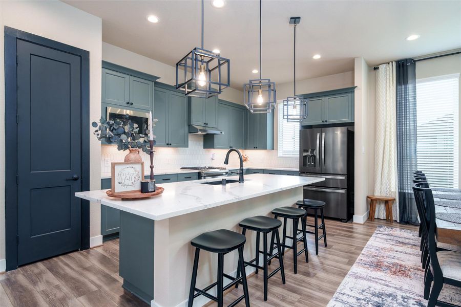 The kitchen is a chef’s dream, featuring custom painted cabinets, sleek, upgraded granite countertops, a spacious kitchen island, and modern pendant lighting that beautifully illuminates the space. The kitchen is a chef’s dream, featuring custom painted cabinets, sleek, upgraded granite countertops, a spacious kitchen island, and modern pendant lighting that beautifully illuminates the space.