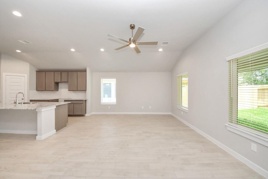 Gather the family and guests together in your lovely living room! Featuring soaring high ceilings, recessed lighting, ceiling fan, custom paint, gorgeous floors, and large windows that provide plenty of natural lighting throughout the day. Sample photo of completed home with similar floor plan. Actual colors and selections may vary.