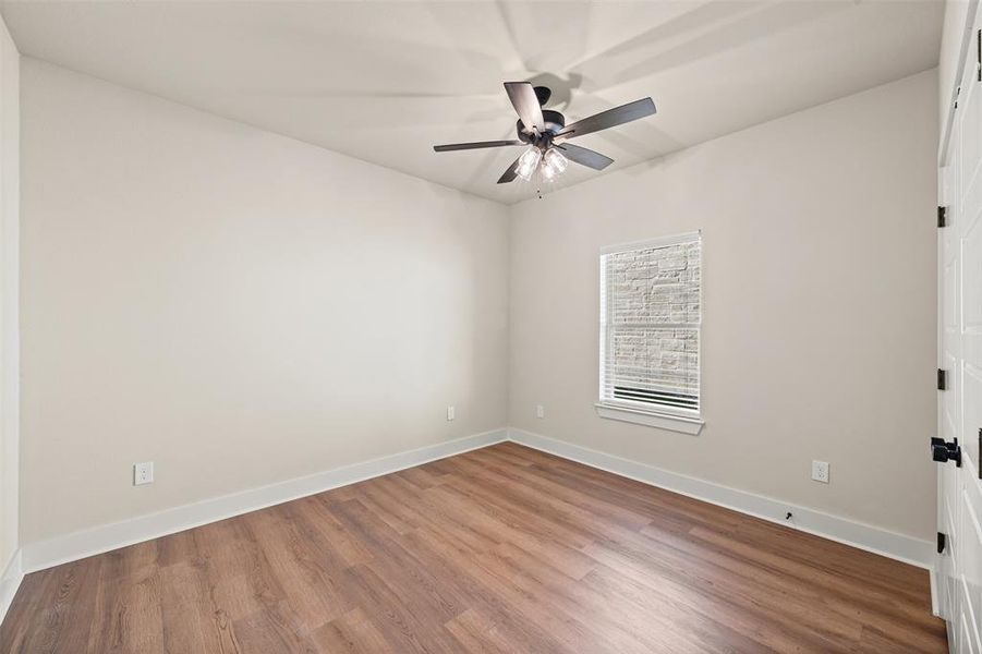 Empty room with wood finished floors and ceiling fan