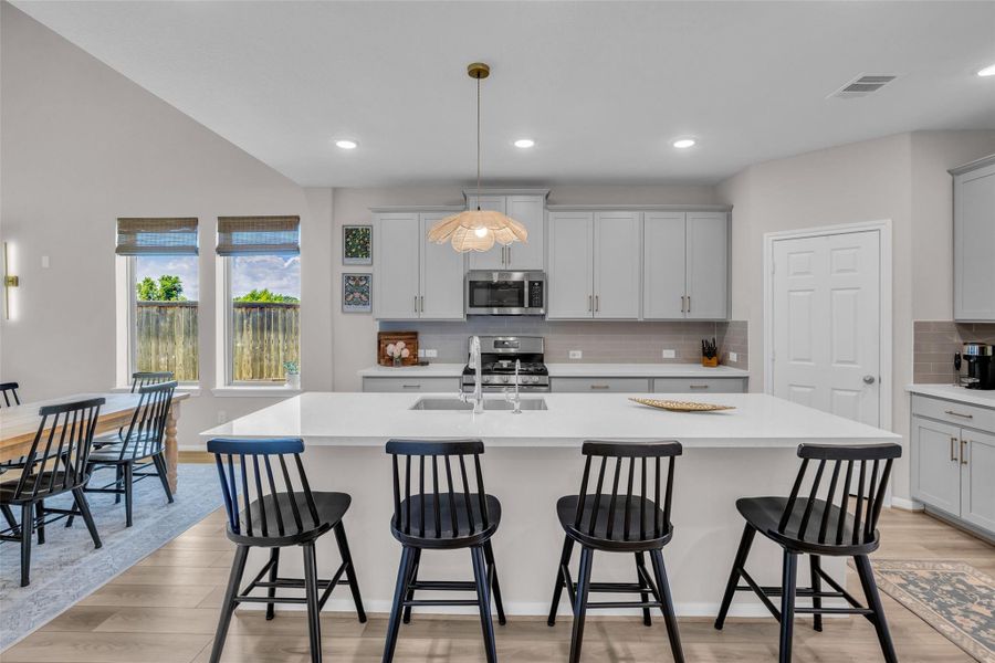 The kitchen is conveniently open to the dining and living areas, creating a connected layout that makes everyday living and entertaining easy.