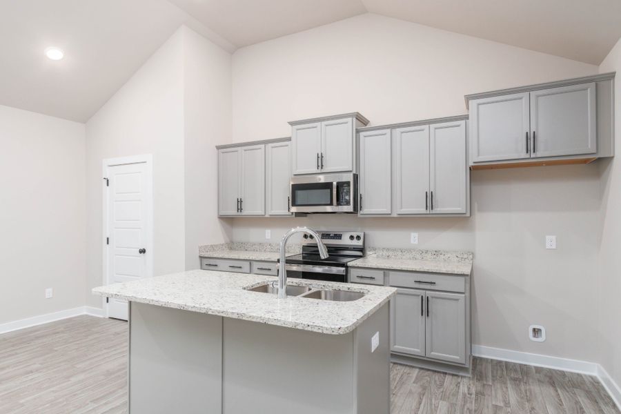 Stone-Grey Aristokraft Cabinetry lined with Granite Countertops make this Kitchen a must have!